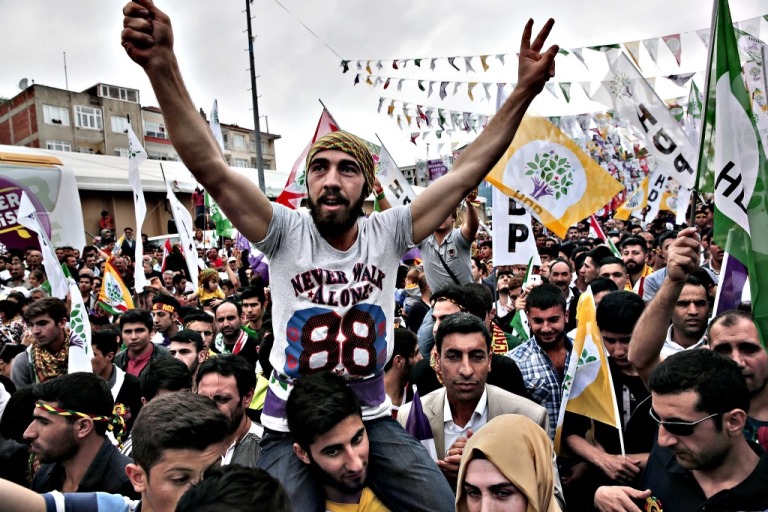 Supporters of the pro-Kurdish People's Democratic Party (HDP) wait for the appearance Selahattin Demirtas, co-chair of the party to deliver an election campaign speech during a rally in Istanbul, Turkey, Thursday, May 21, 2015, before Turkey's general election on June 7.  The ADP is a small party, but if it gains 10 percent of the vote it will enter parliament as a party, and could change the face of the country's politics. AP Photo/Lefteris Pitarakis)
