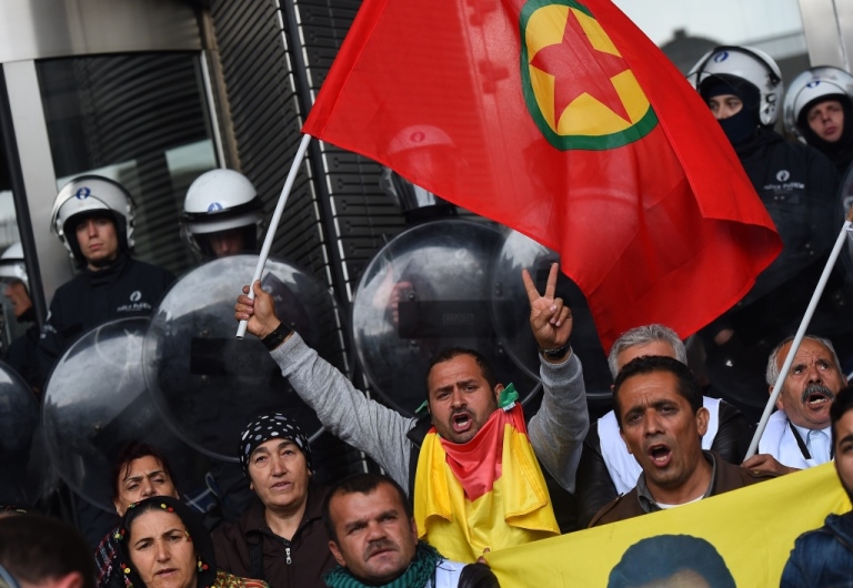 Protesters chant slogans while waving a Kurdistan Workers' Party (PKK) flag as riot police guard the main entrance of the European Parliament during a demonstration calling for support for the Syrian Kurdish town of Ain al-Arab, known as Kobane by the Kurds and currently besieged by the Islamic State (IS), in Brussels on October 7, 2014. Islamic State jihadists pushed into the key Syrian town of Ain al-Arab (Kobane) on the Turkish border, seizing three districts in the city's east after fierce street fighting with its Kurdish defenders. AFP PHOTO/EMMANUEL DUNAND        (Photo credit should read EMMANUEL DUNAND/AFP/Getty Images)