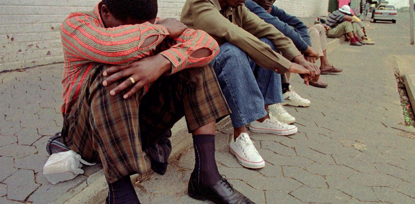 FOR RELEASE WITH FEATURE BC-SAFRICA-JOBS-Unemployed South Africans wait for work outside a factory gate in downtown Johannesburg. One of the cruellest fates that has hit South Africa since apartheid has been unemployment. Picture taken October 26, 1998. JN/FMS - RTRIPTE